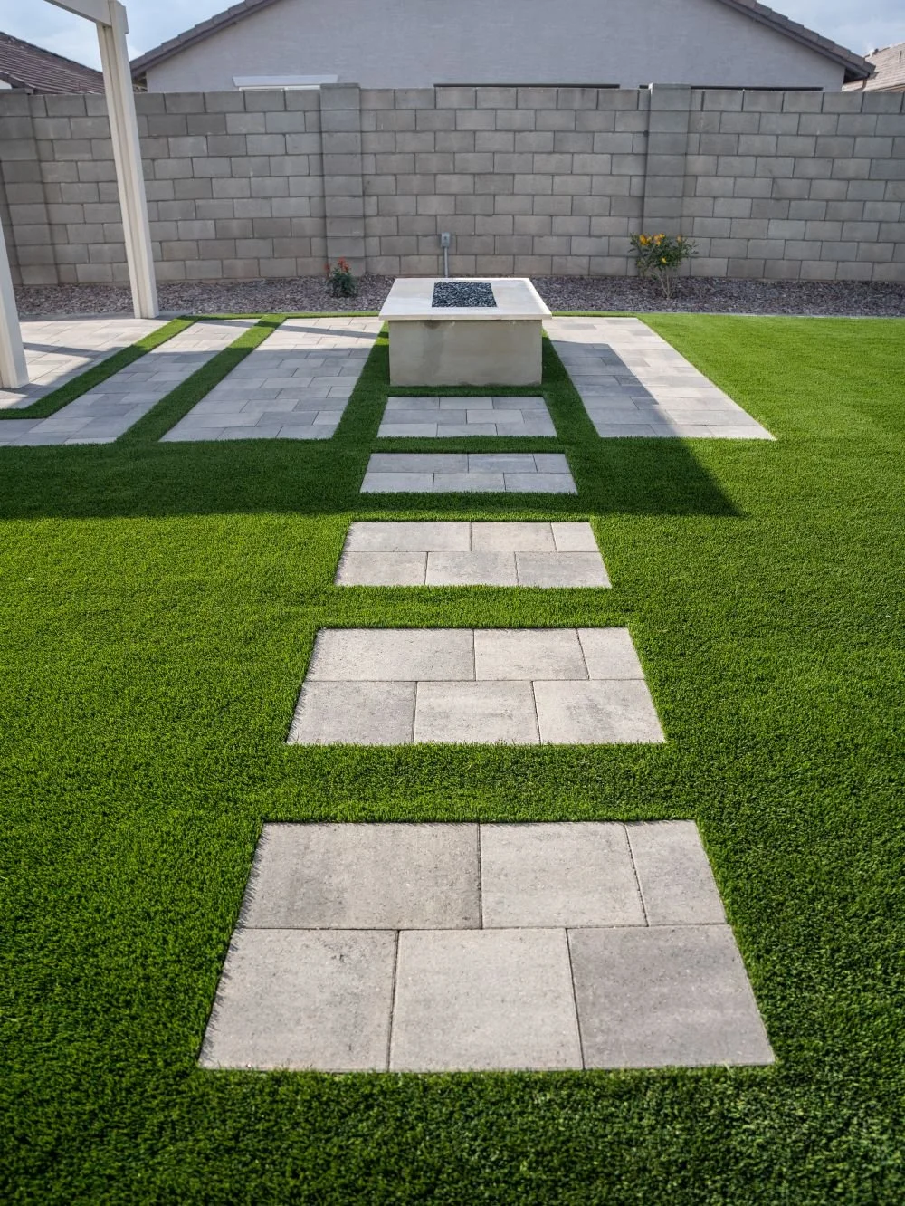 A paver walkway set in artificial turf in Scottsdale, AZ leading to an outdoor fireplace