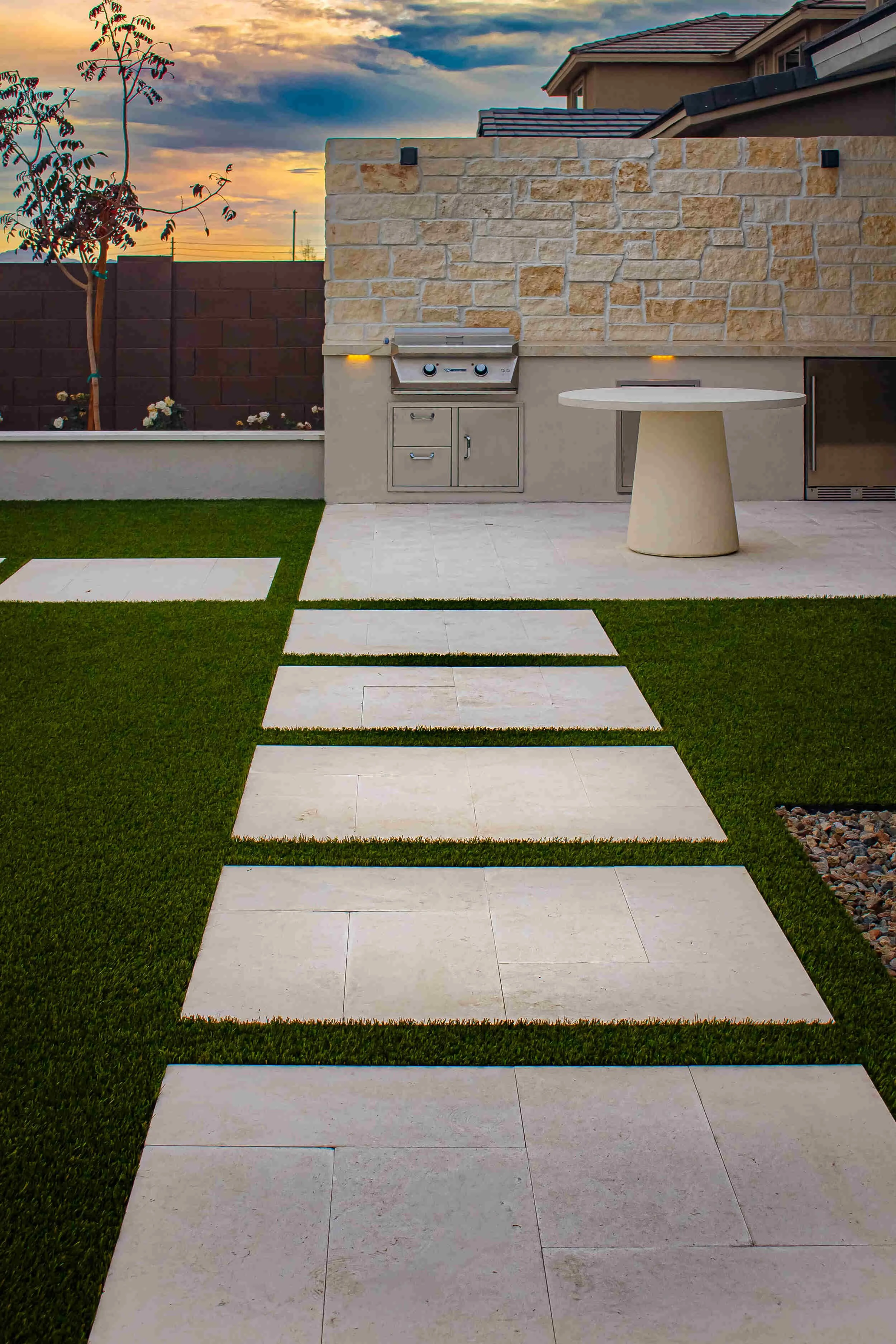 A walkway in Arcadia, AZ with concrete pavers set in artificial turf as part of landscape design