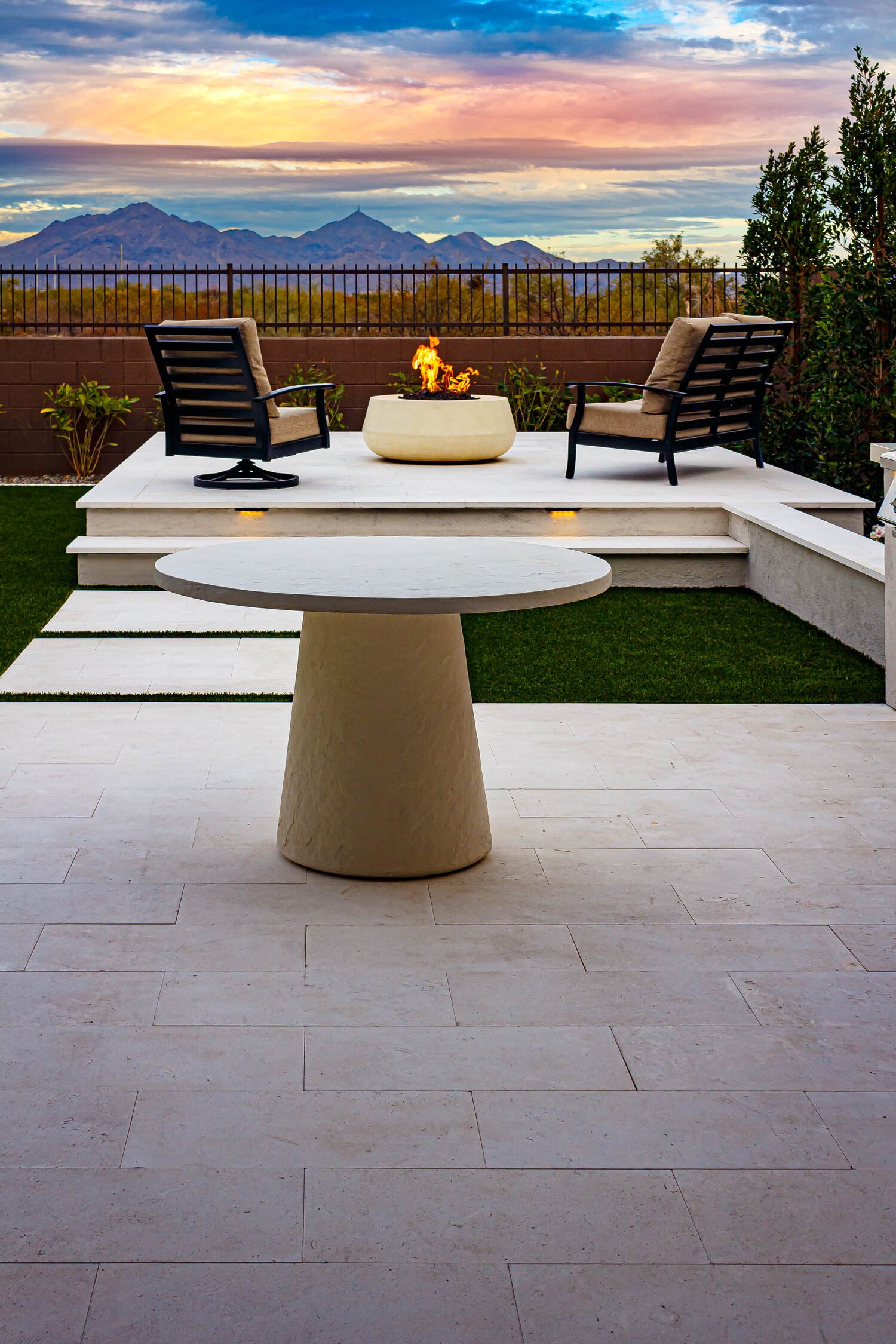 Fire features with accent lighting creating a warm glow on a dining patio in Paradise Valley, AZ