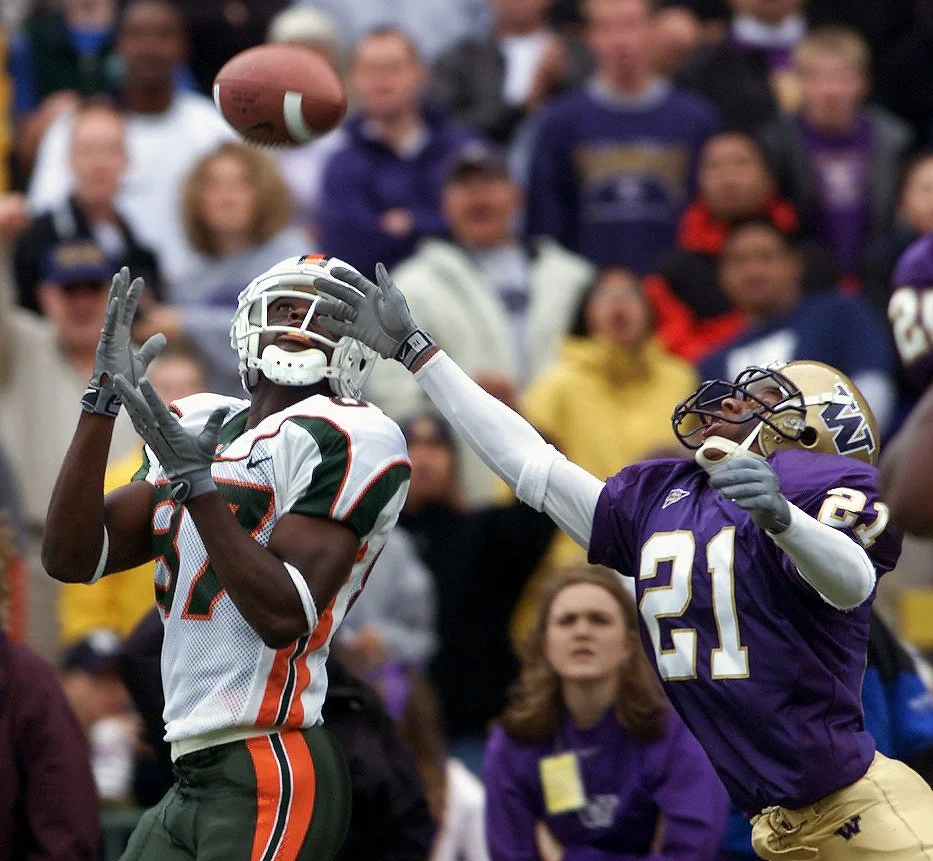 University of Miami wide reciever Reggie Wayne pulls in a touchdown pass of Husky cornerback Derrick Johnson.