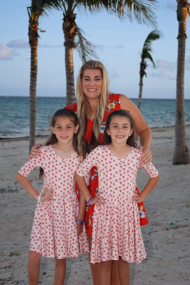 Hey mom and her two daughters on the beach with palm trees in the background in Cancun Mexico