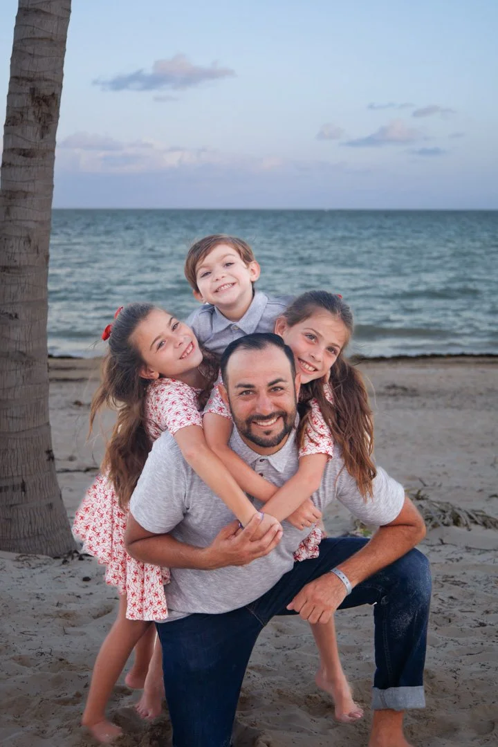 A father and his three children on the beach Cancun Mexico