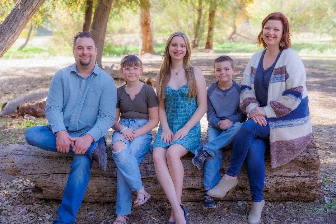 A family portrait taken on a log at Glen Arbor Park in Murrieta