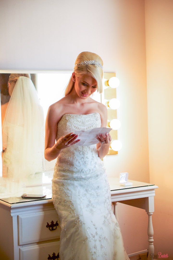 A bride reading a letter from the groom prior to her wedding