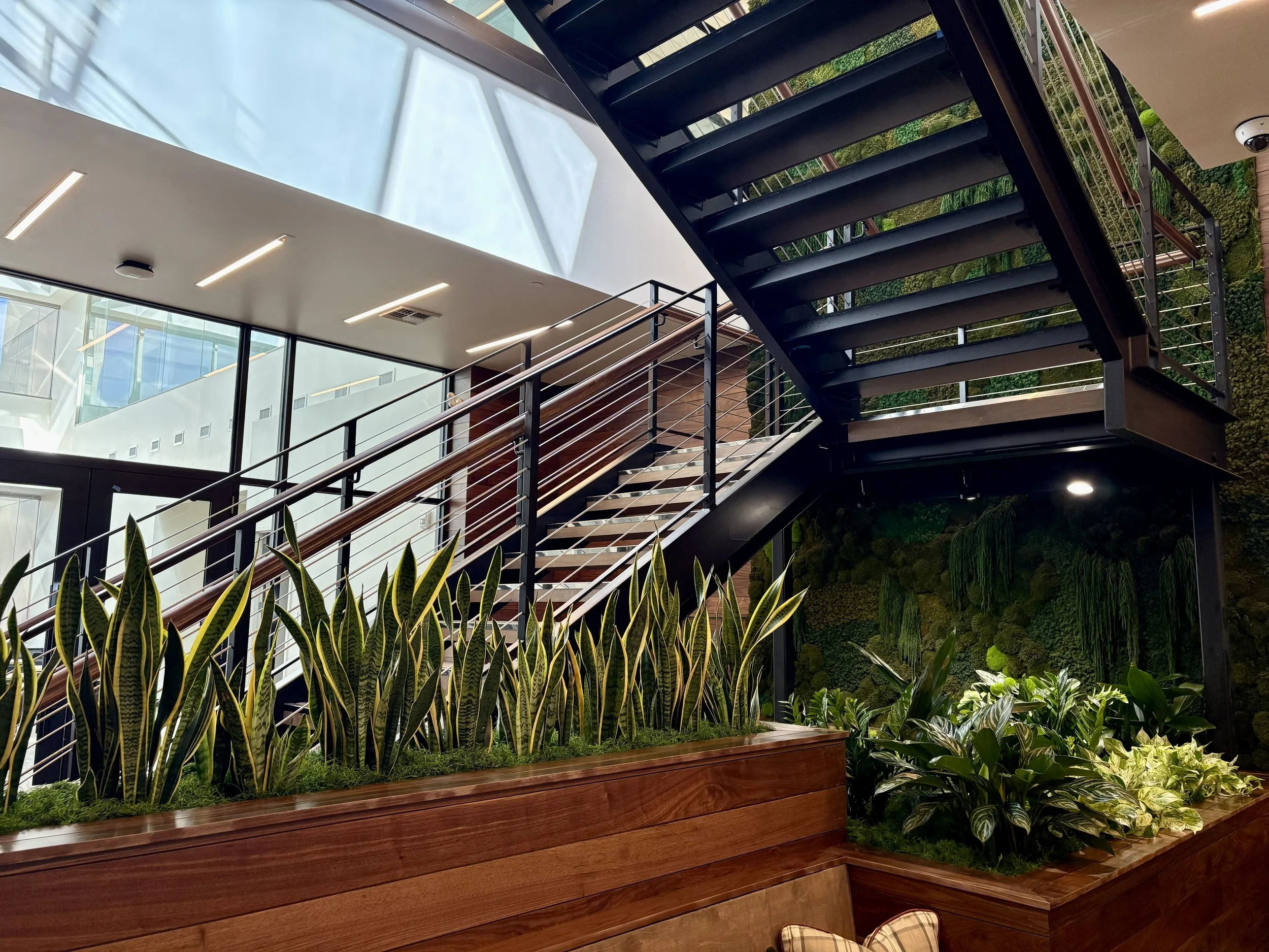 Large planted with live plants under a metal staircase 