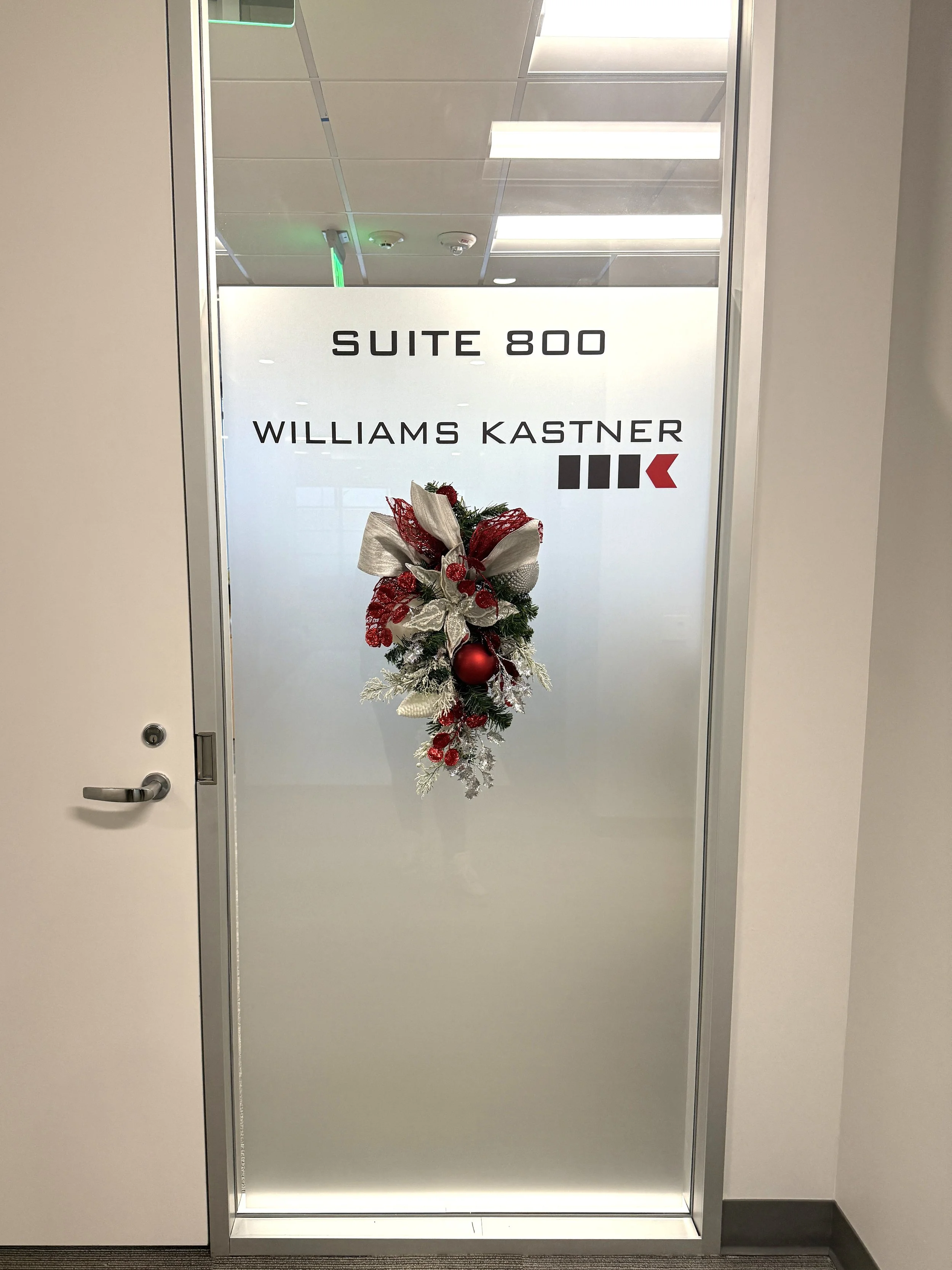 Holiday teardrop with red and white ornaments, on the wall entrance to a commercial office.