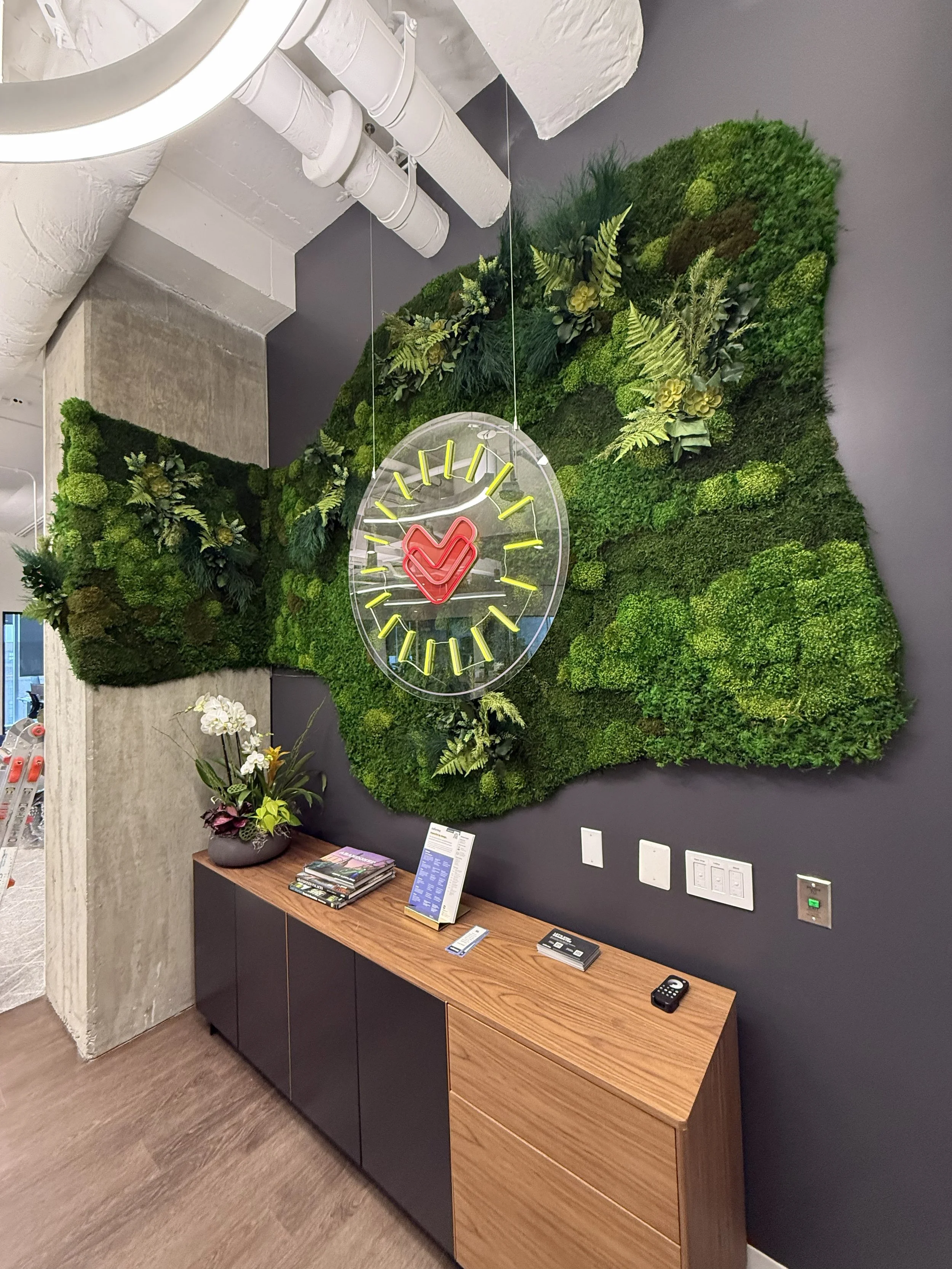 Wraparound moss wall above cabinet. Overlayed hanging sign in front.