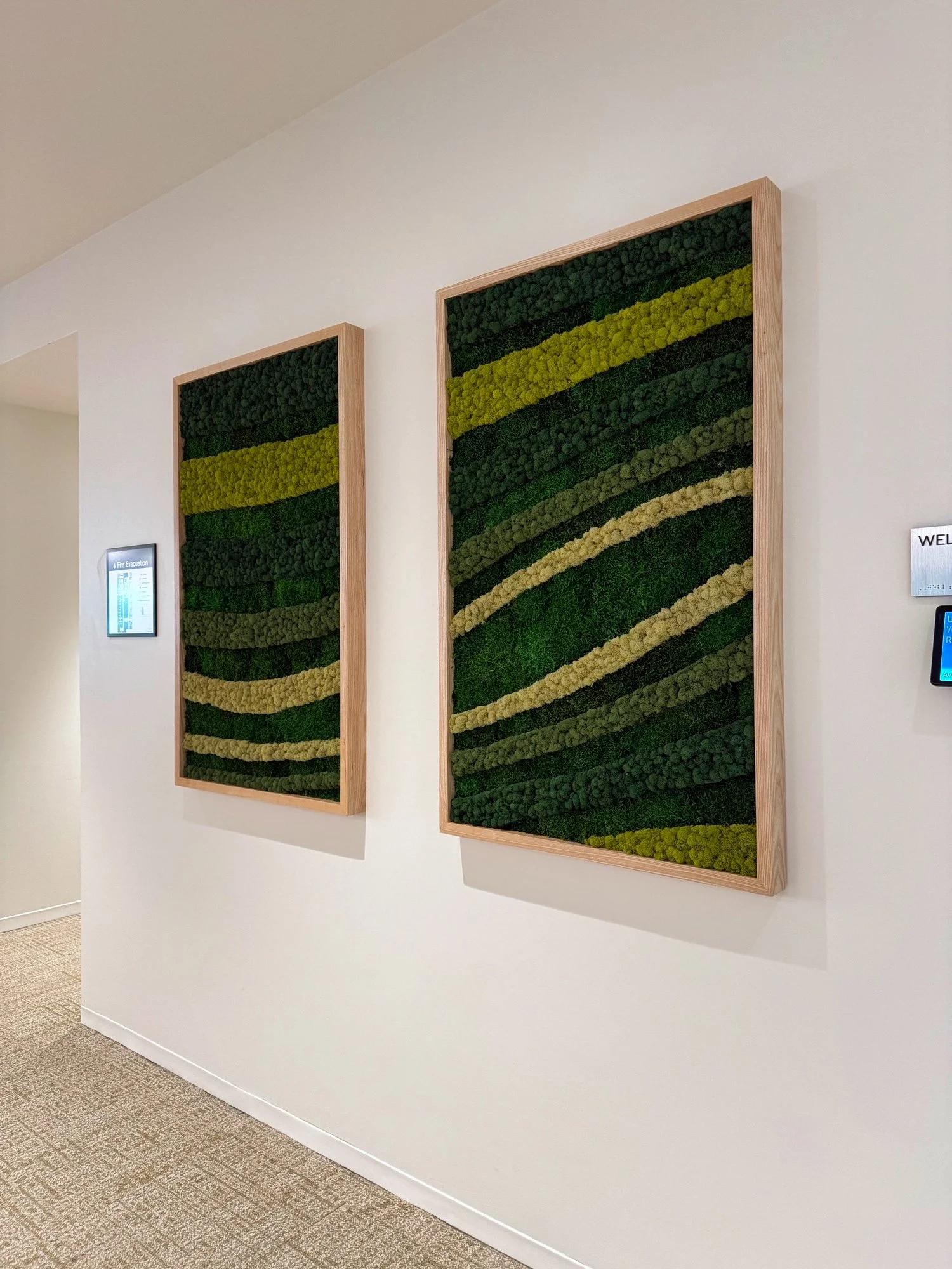Two framed moss walls. Natural wood finish with flowing design.