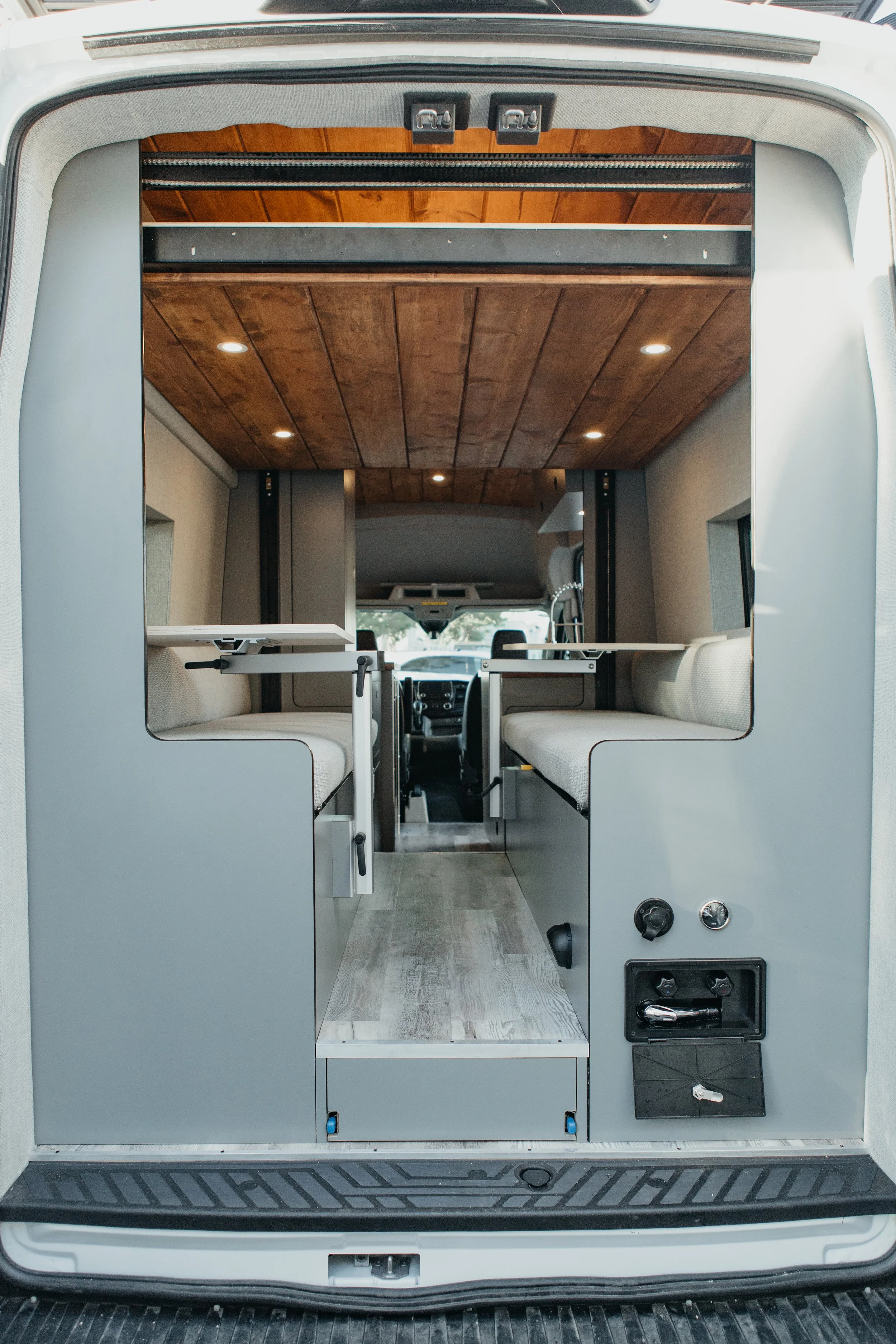 Scandinavian-Modern conversion van interior featuring a lagun table and custom bench seats.