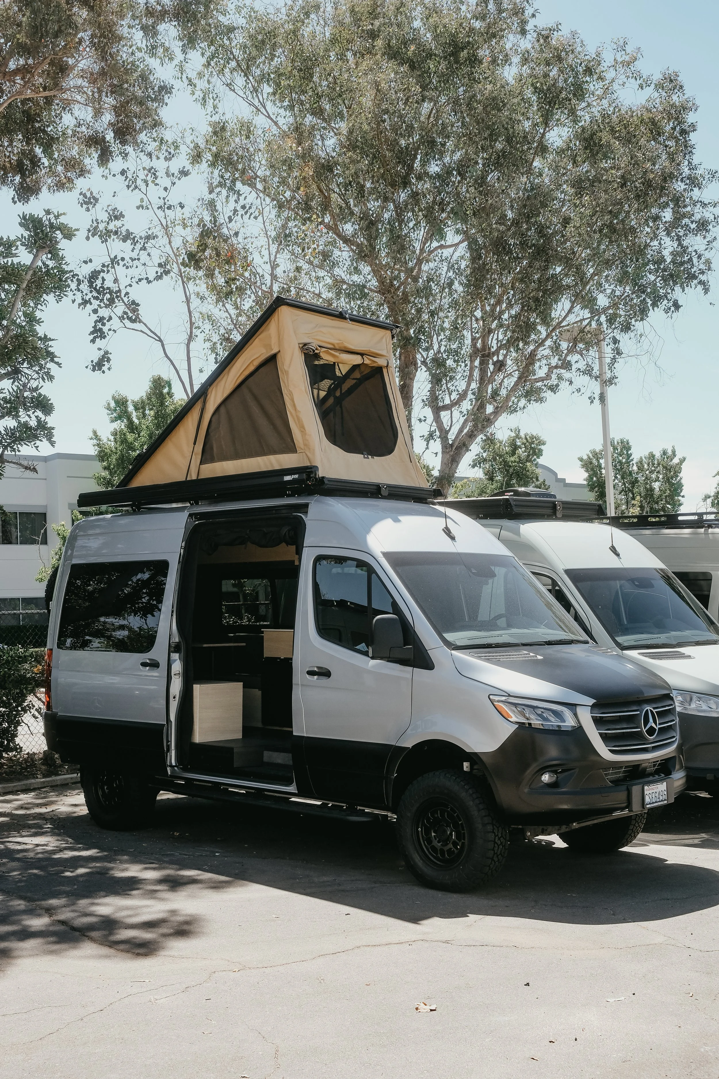 Side view of a Mercedes sprinter can with a super pacific roof tent popped up 