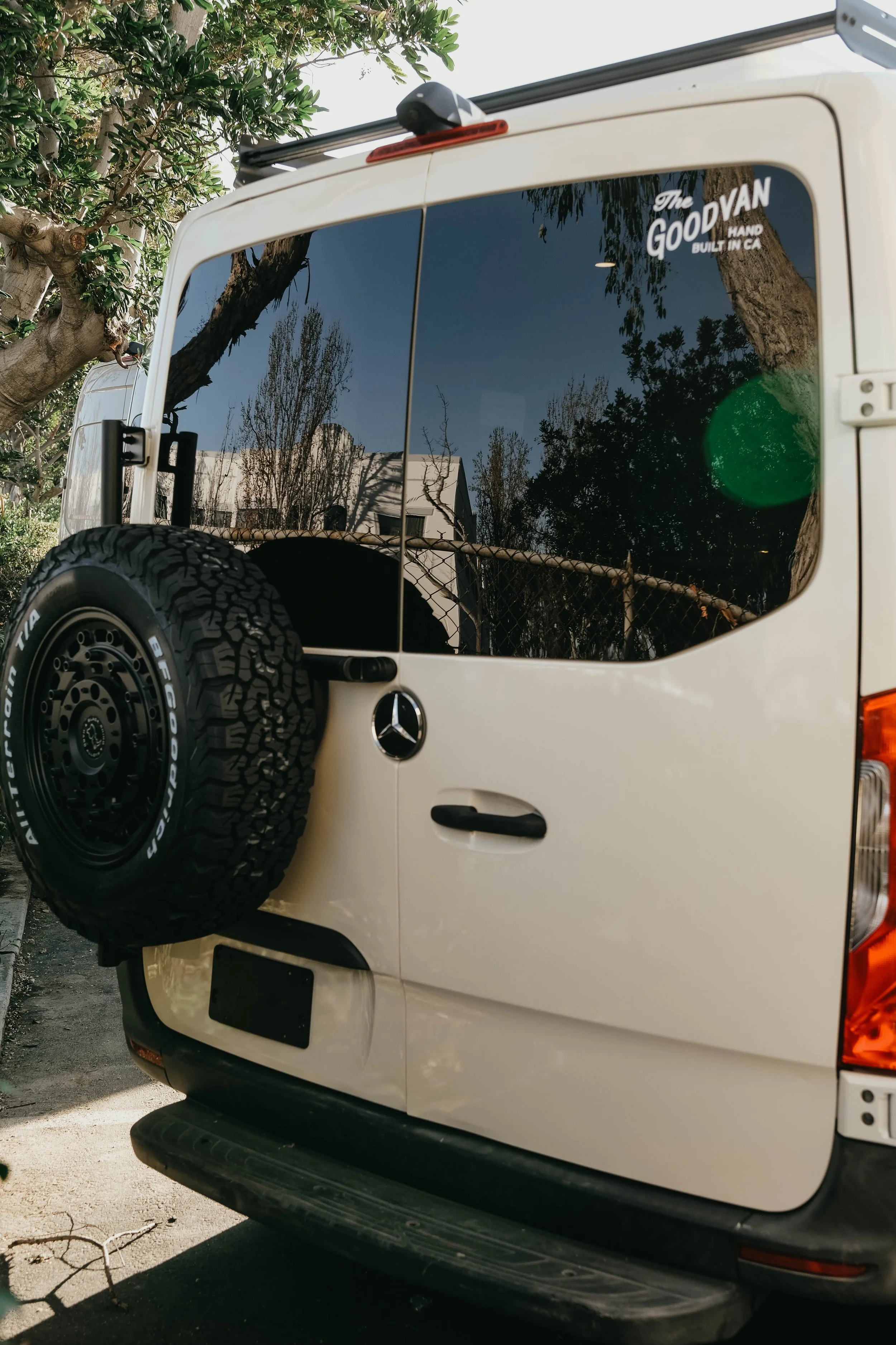 Rear of Mercedes sprinter van with tire carrier and roof rack