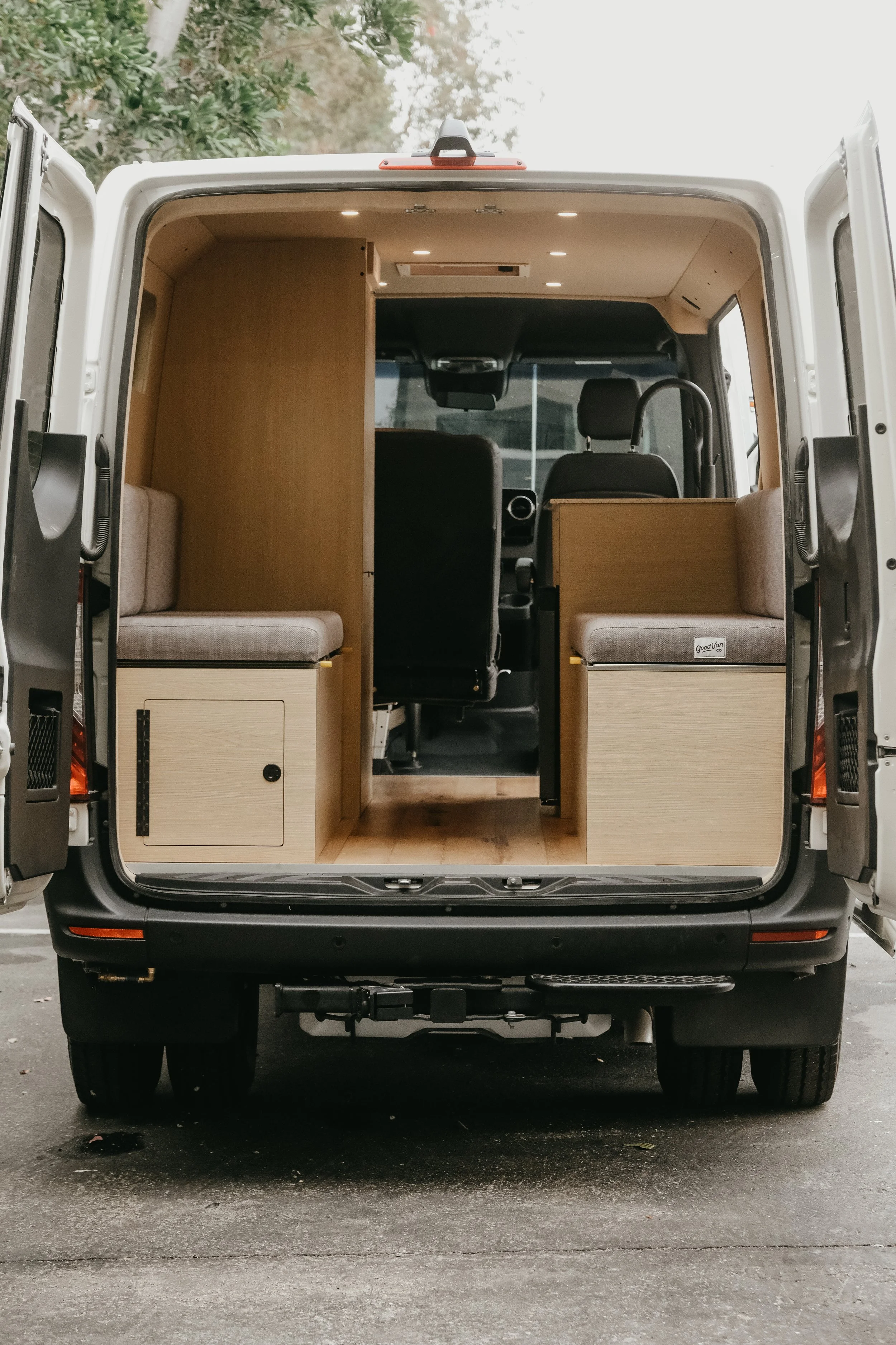 Rear view of a mercedes sprinter van with an interior build featuring two custom bench seats facing each other