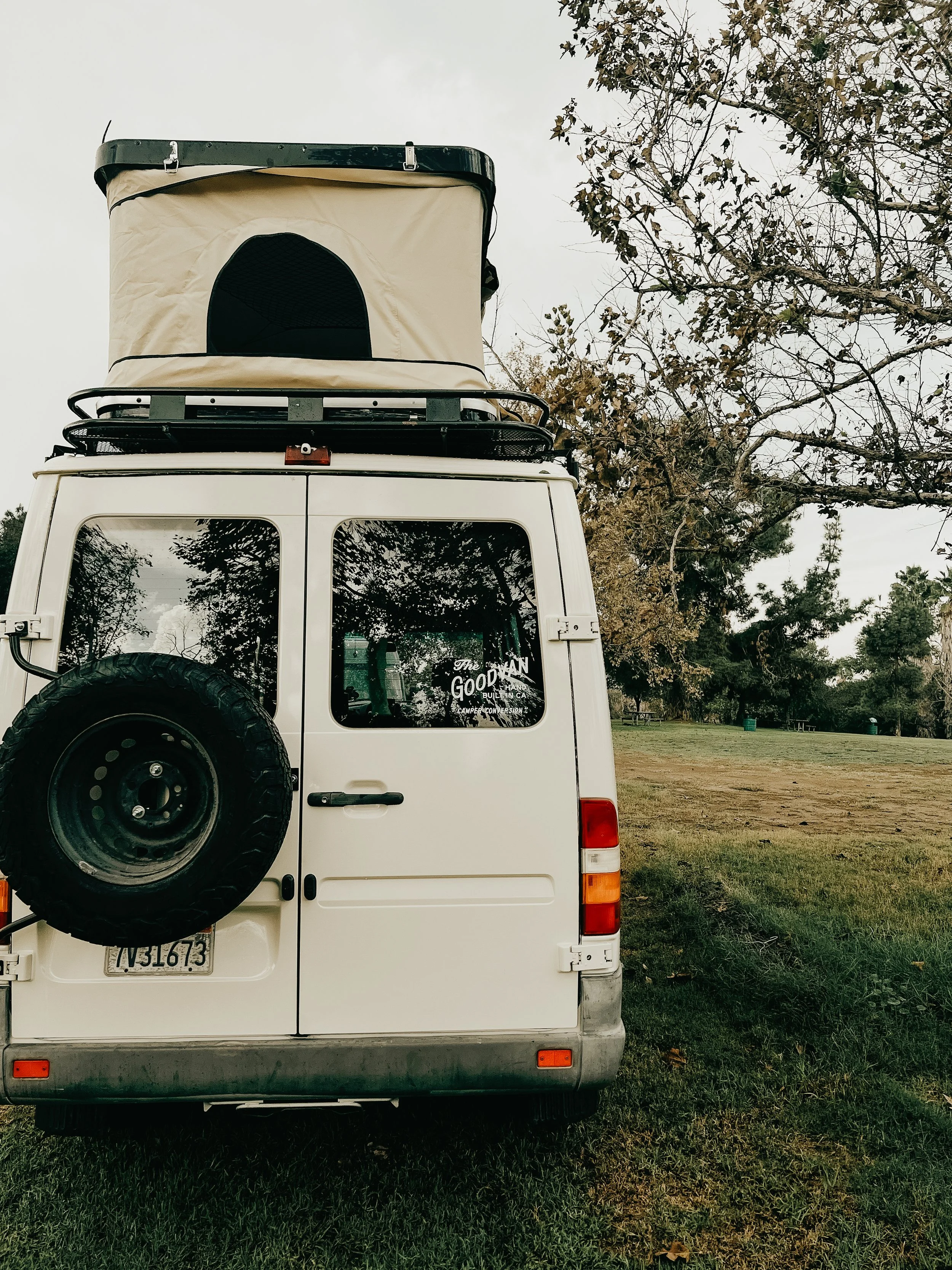 Rear of vanlife builds with roof top tent, roof rack, and tire carrier