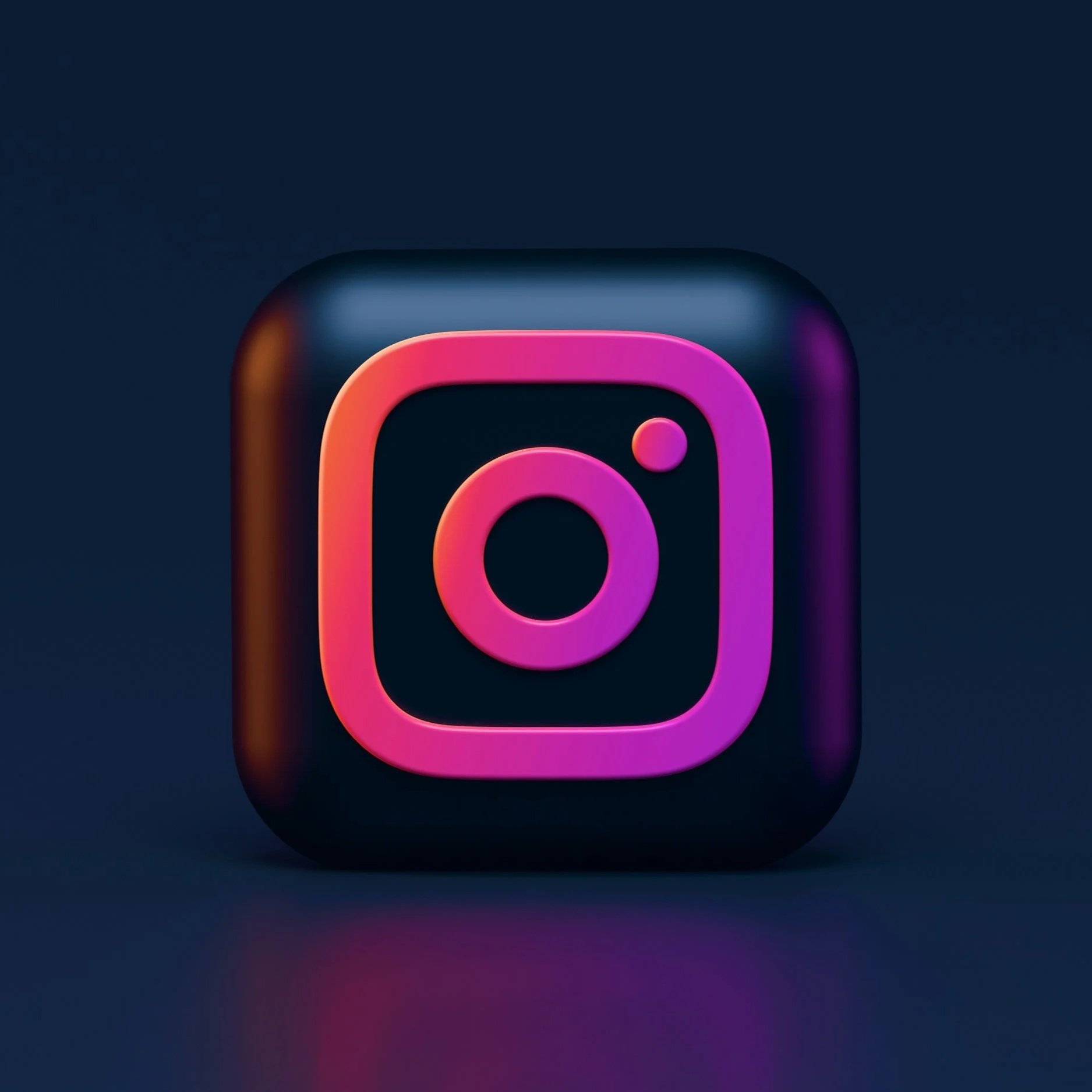 3D digital icon of the Instagram logo with pink and purple neon colors on a dark background.