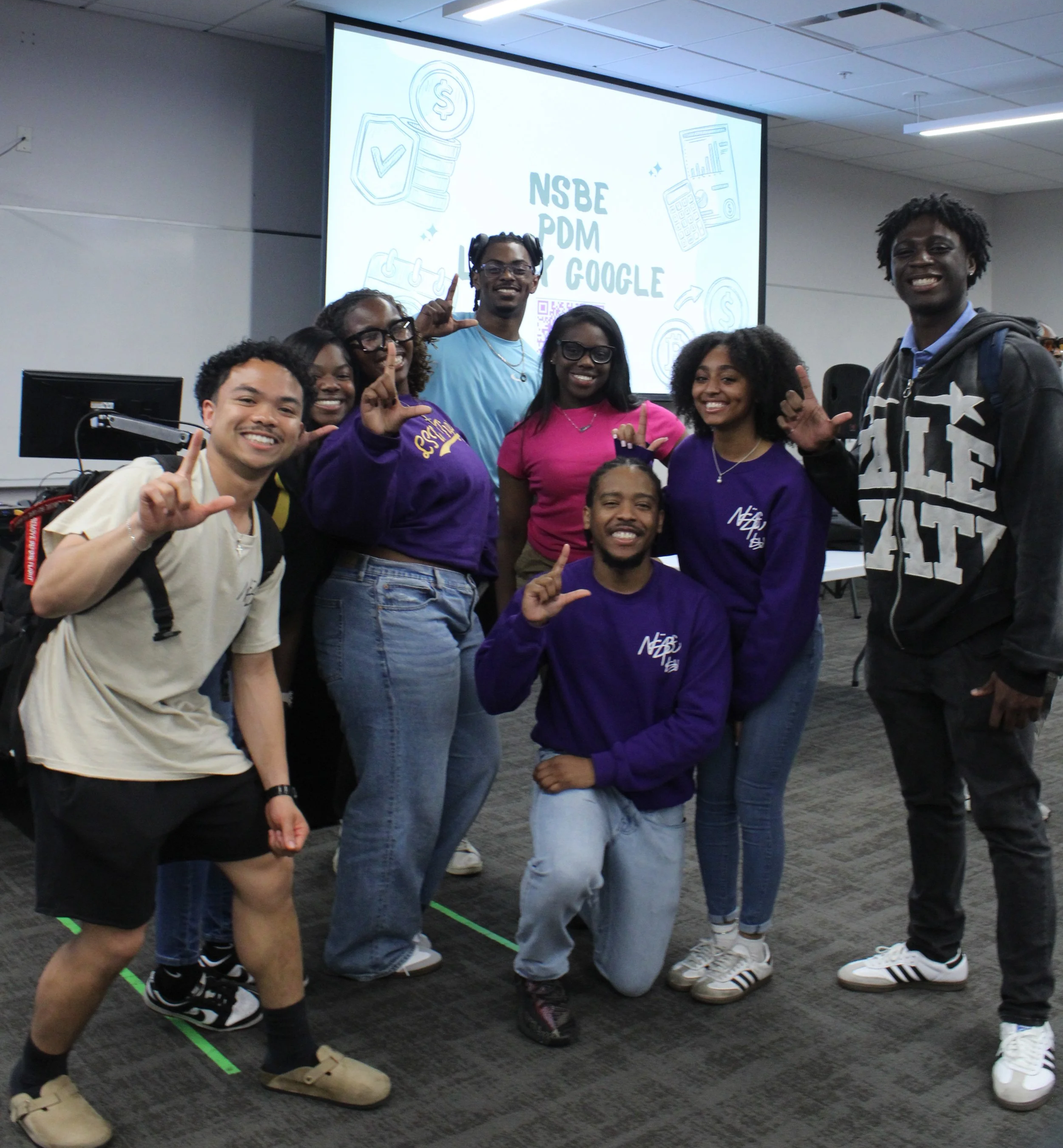 NSBE Members posing together making a "L" sign with their hands