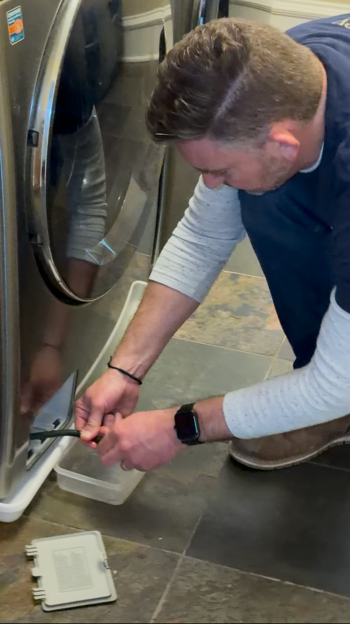 Laundry appliance inspection during a home watch visit.