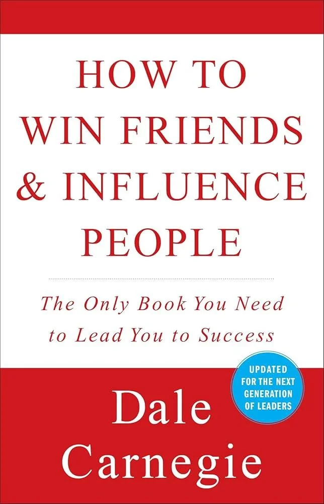 Book cover titled "How to Win Friends & Influence People" by Dale Carnegie, with a blue sticker indicating "Updated for the Next Generation of Leaders."