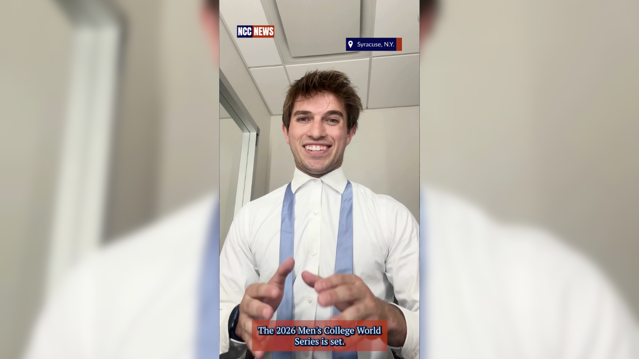 Man smiling in an office, wearing a white shirt and blue tie, with NCC News and Syracuse, N.Y. labels at top and a caption at bottom that reads "The 2026 Men's College World Series is set."