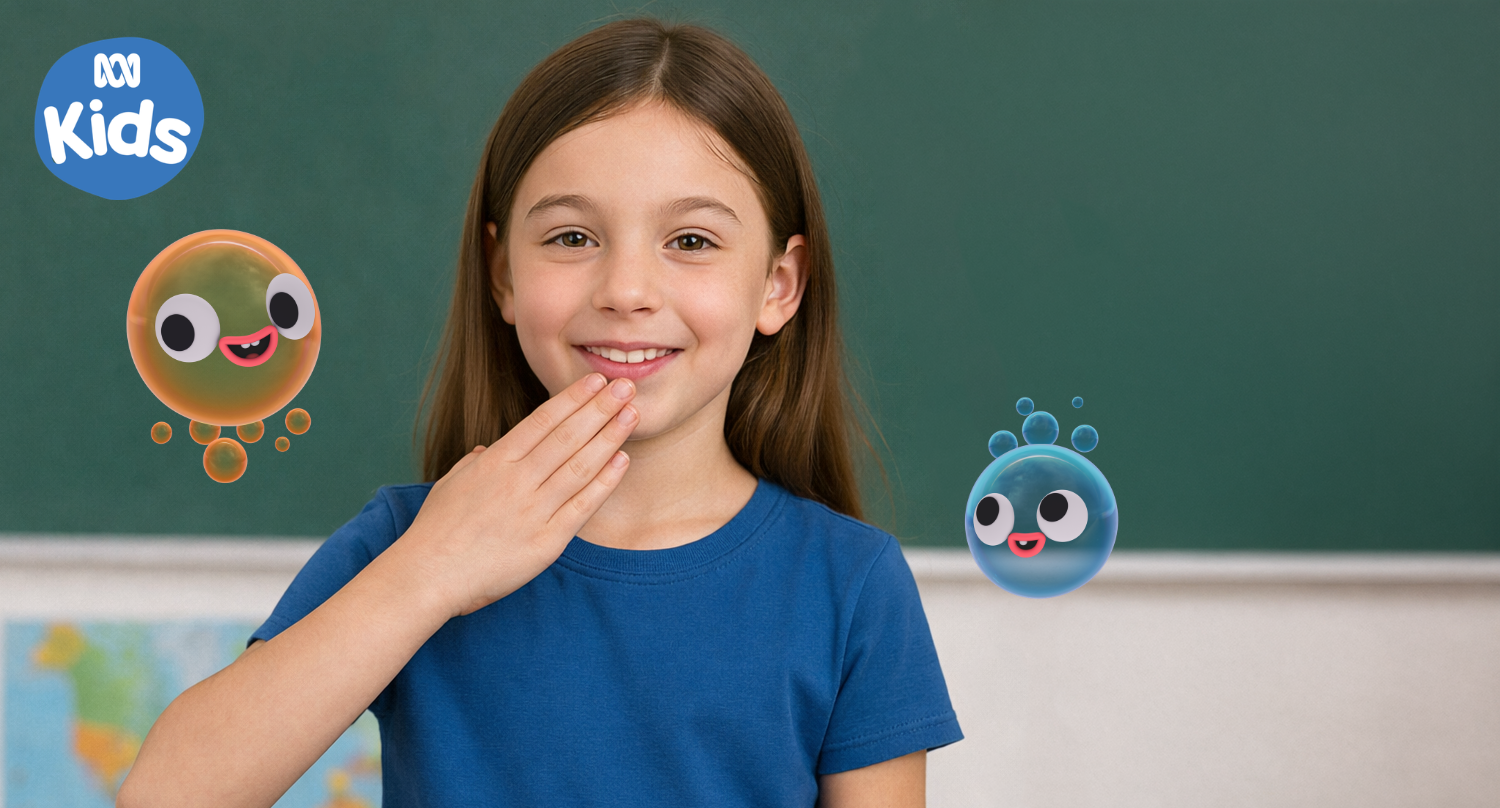 A young girl smiling in a classroom with animated cartoon germs around her, one orange and one blue, representing cleanliness and germs.