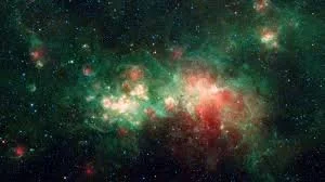 A colorful view of outer space with stars, nebulae, and cosmic clouds in shades of green, red, and white.