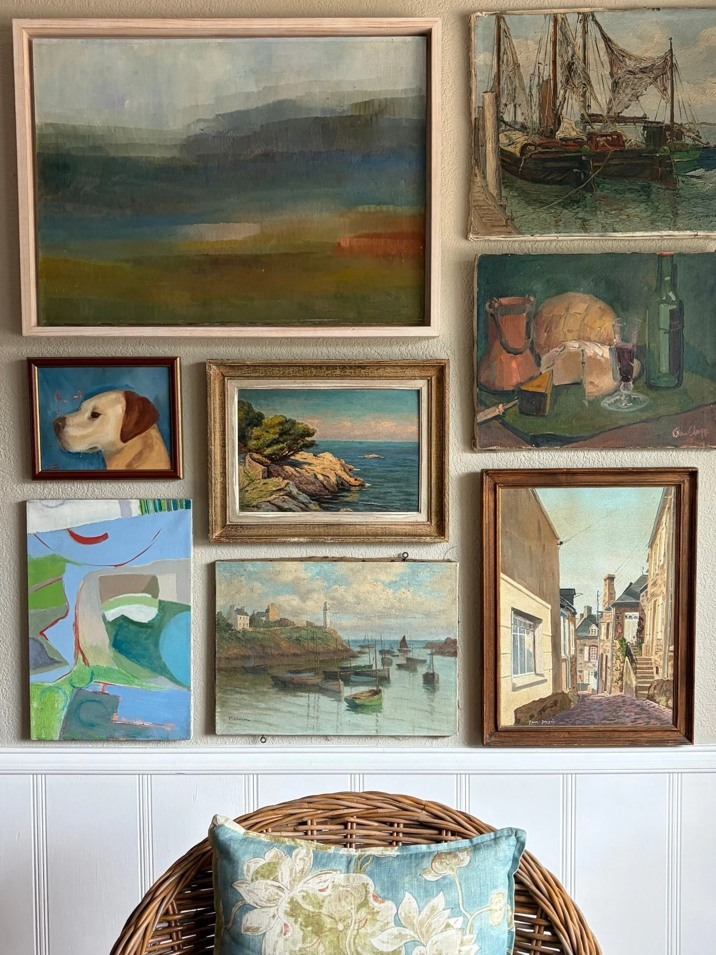 Rainy day gallery wall install last Sunday. Different artists, different decades, different moods, and somehow they all belong. 🎨

A misty abstract landscape, a lighthouse harbor, a still life with bread and wine, and a golden lab. The common thread