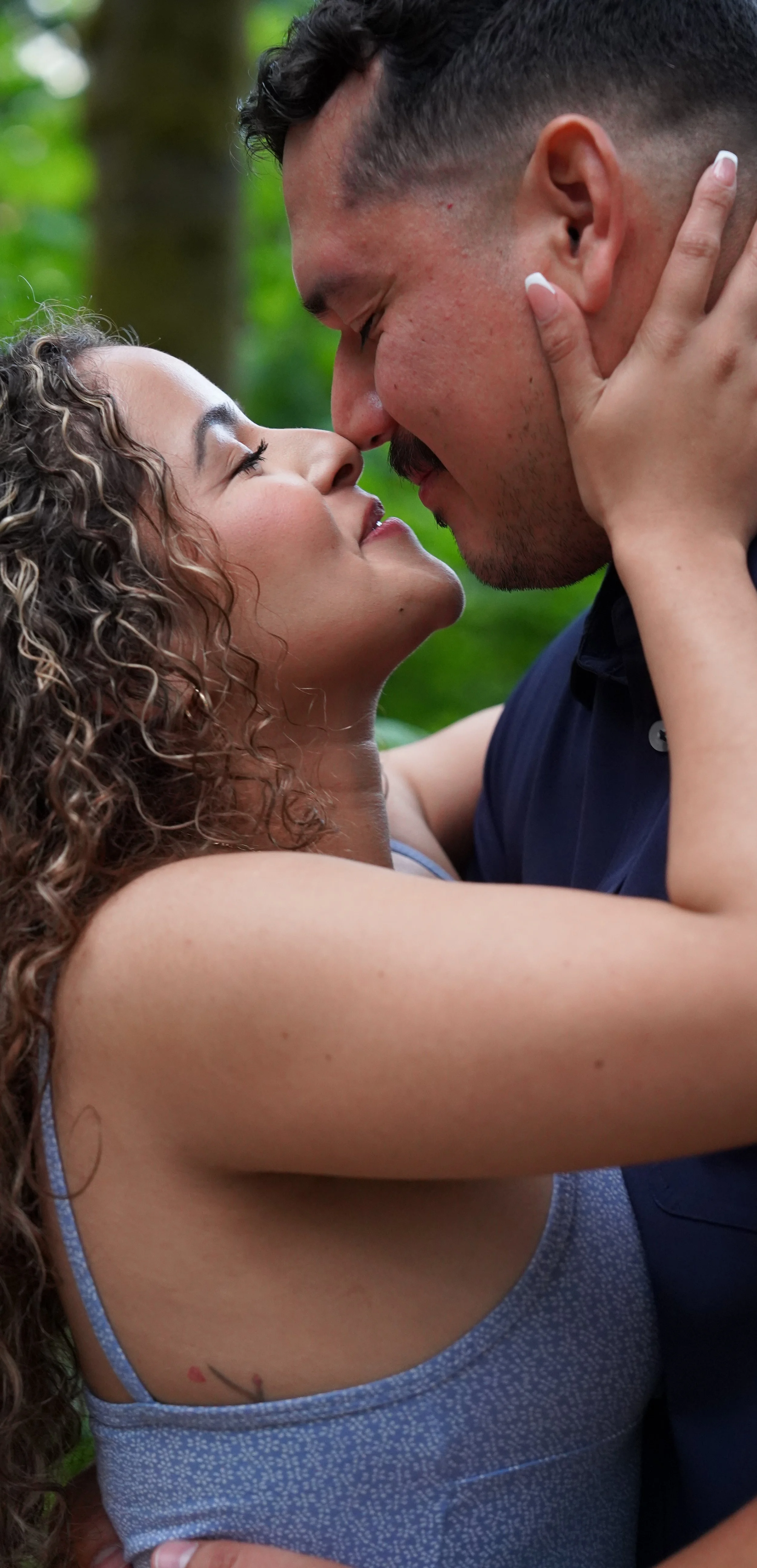 Newly engaged couple kissing in the Western Washington forest.