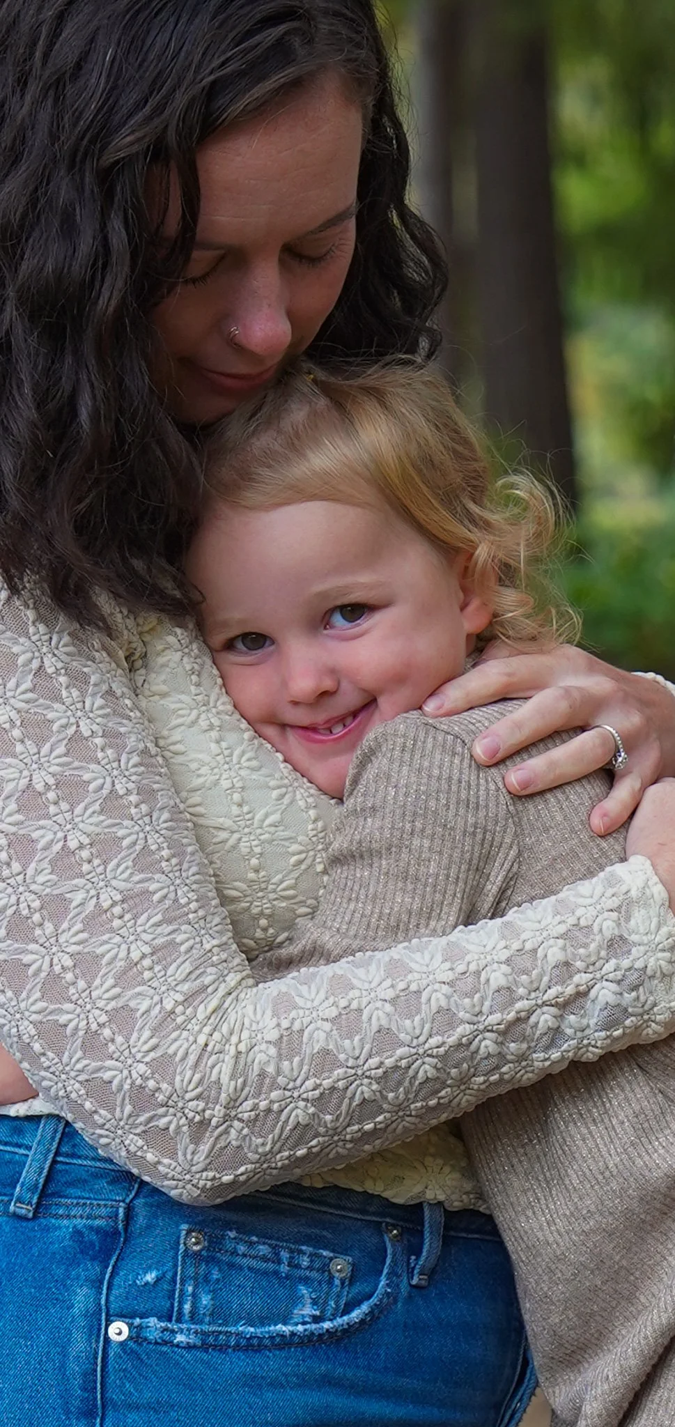 Mother holding her daughter close.