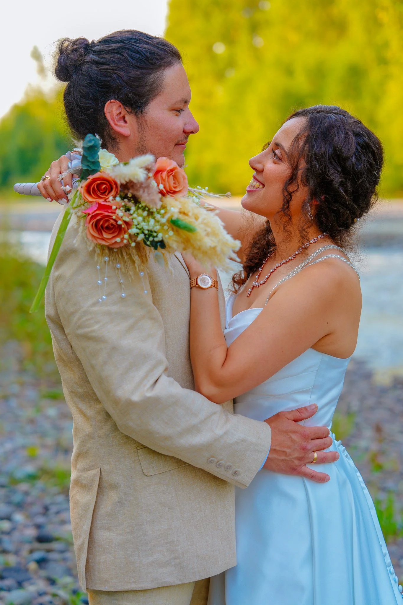 Newly weds hold each other by the river at Monarch Meadows in Orting, Washington.