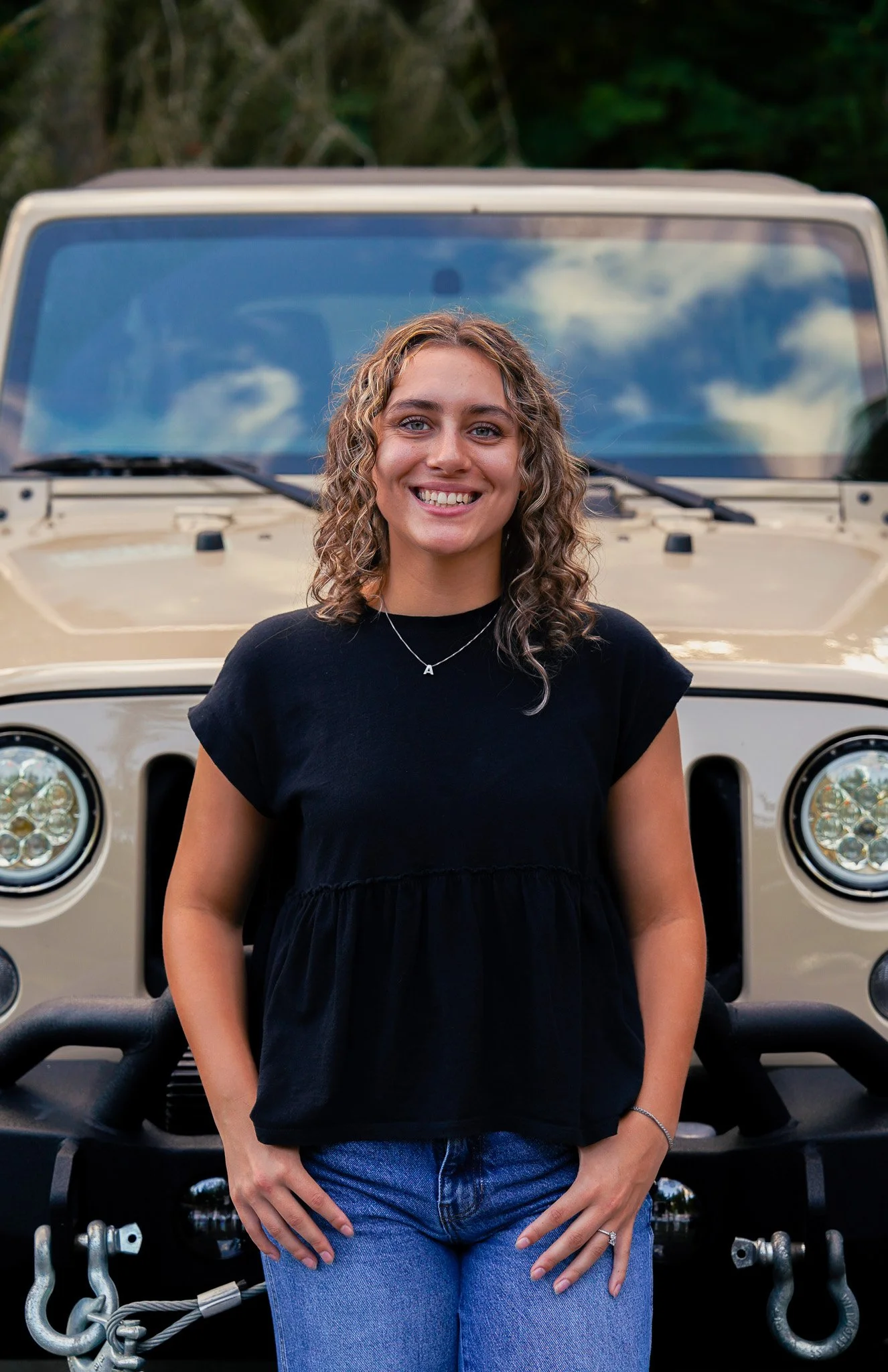 Senior standing in front of her car.