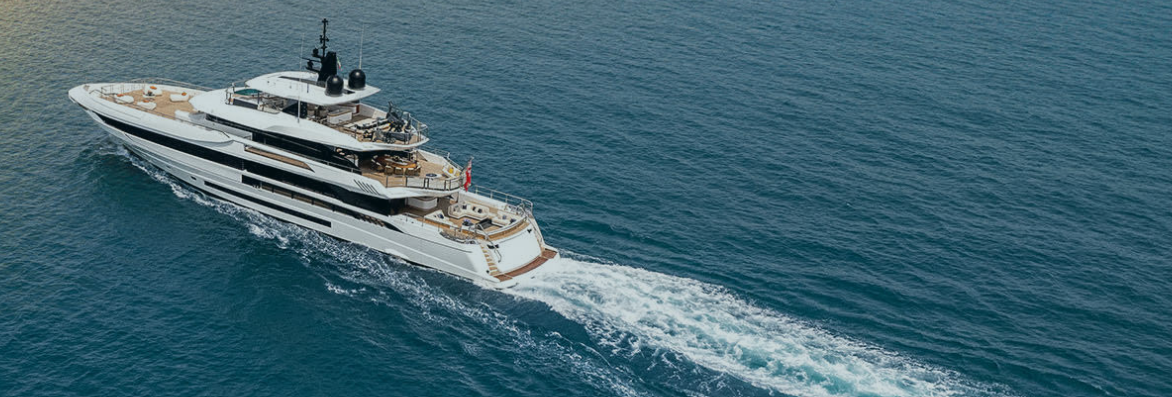 A large luxury yacht sailing on the ocean with a visible wake behind it.