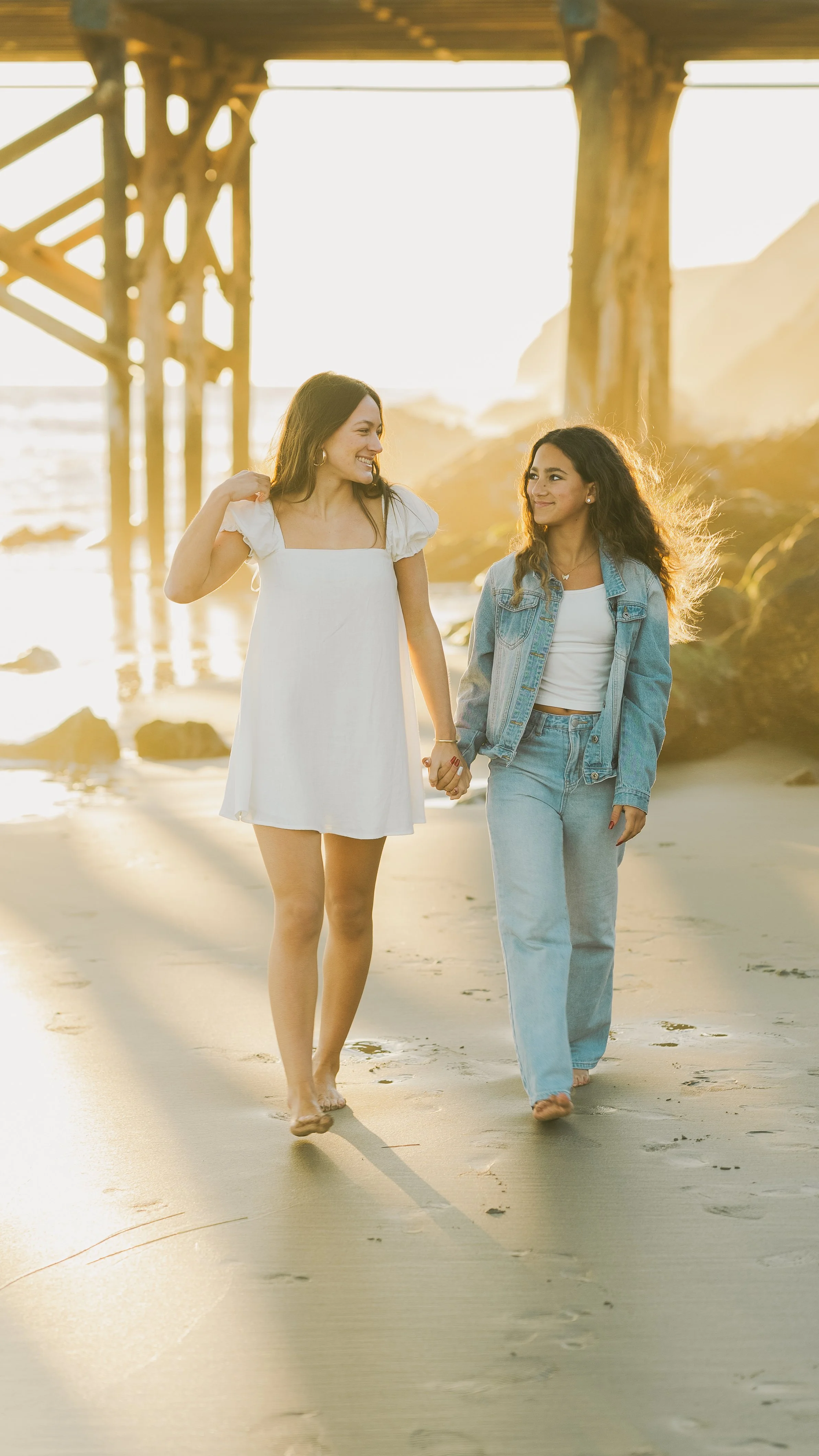 Two women walking on a Central Coast beach at sunset, captured during an outdoor lifestyle shoot for social media video content.