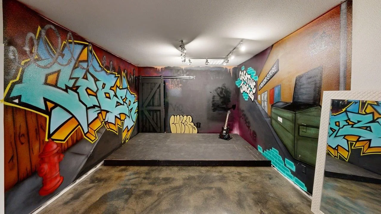Unique urban street-style film set featuring custom graffiti wall art, a stage, and street props for creative video production.