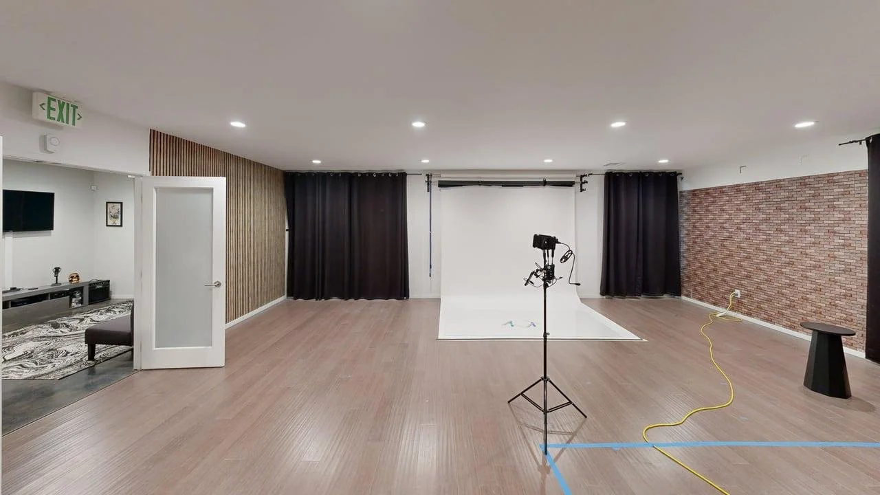 A clean, open studio rental space featuring a white seamless backdrop perfect for commercial photography and brand videos.