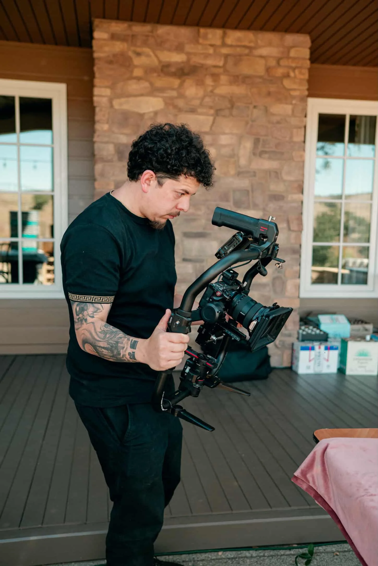 Behind-the-scenes photo of professional cinematographer Juan operating a stabilized camera gimbal rig during an on-location video production shoot on the Central Coast.