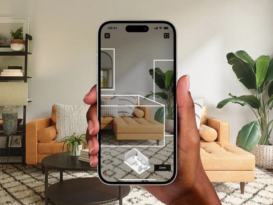 Hand holding a smartphone displaying an interactive 3D LiDAR scan of a living room, showcasing virtual tours and property documentation services for Central Coast real estate.