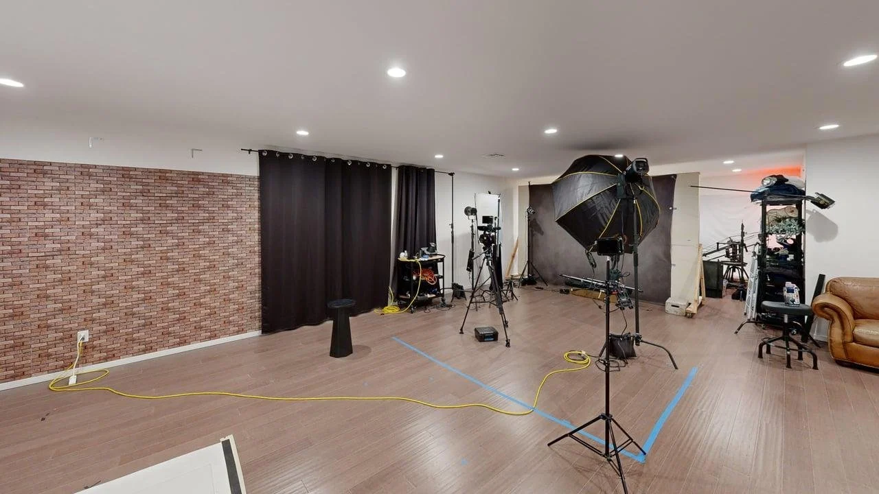 Professional photography and video production set equipped with strobe lighting, modifiers, and dark curtains at CreativeJuices Studio.