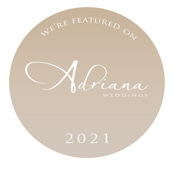 Circular logo with beige background and black border, featuring the text "We're featured on Adriana Weddings 2021" in white, cursive and uppercase fonts.