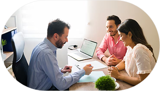 A man in a suit talking to a woman and man in a meeting room