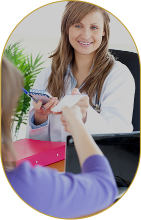 A female doctor smiling and taking notes while speaking with a patient in a medical office.