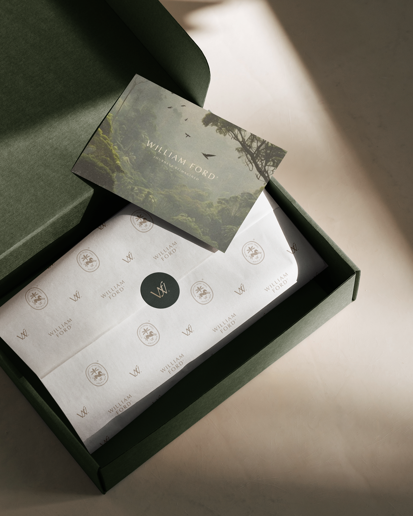 Open green box containing branded paper and a card with nature scene and the text "WILLIAM FORD, JOURNEYS REIMAGINED."