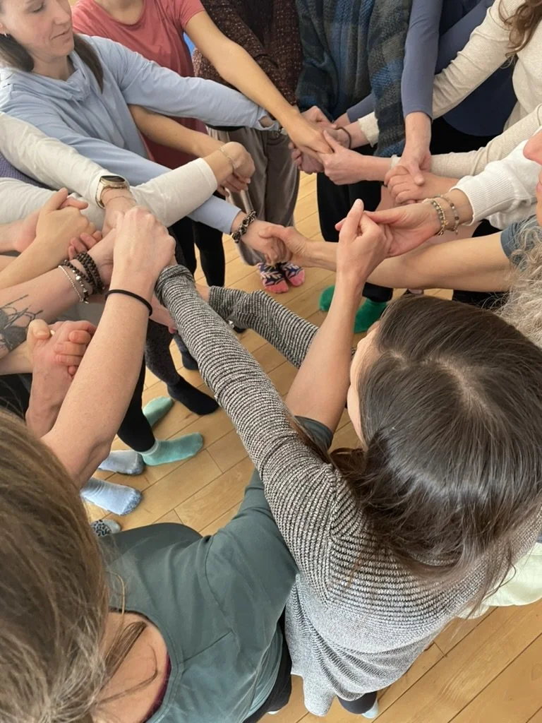 Mehrere Menschen halten sich an den Händen in einem Kreis, für eine Teamaktivität oder ein Gruppenspiel.