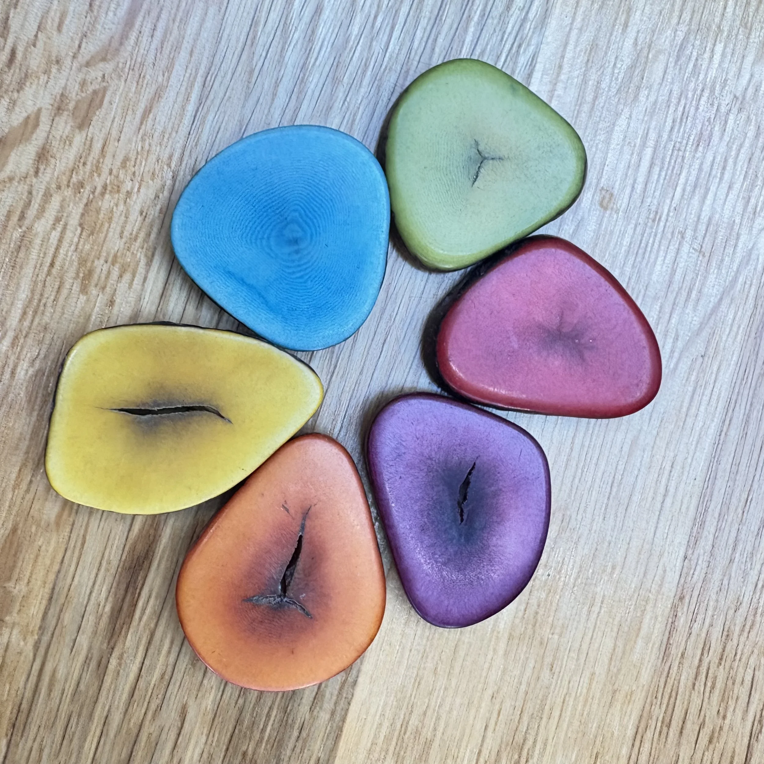 Colored wooden slices shaped like fruit on a wooden surface.