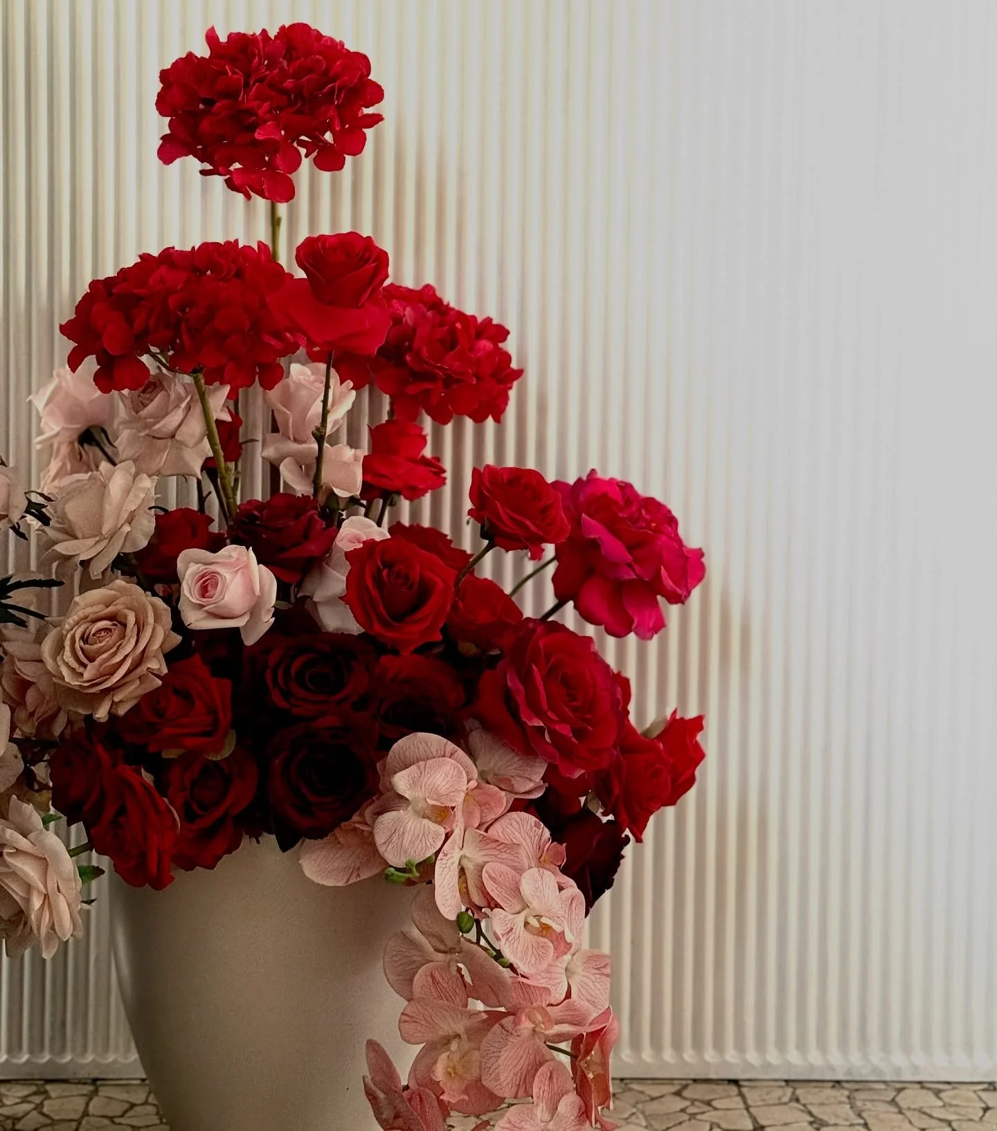 We styled our ripple and single arch backdrops with layers of rich red and pink florals, paired with our burgundy signage for a bold statement &amp; ripple plinth. Premium silk faux florals bring elegance, texture and beauty. 

For all enquiries:
📧 