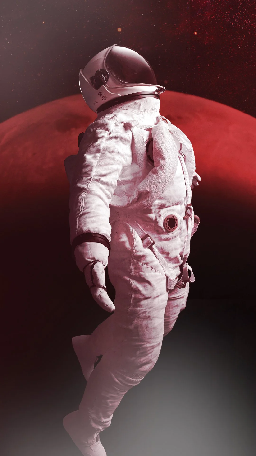 An astronaut in a white space suit standing in front of a large red planet against a dark starry background.