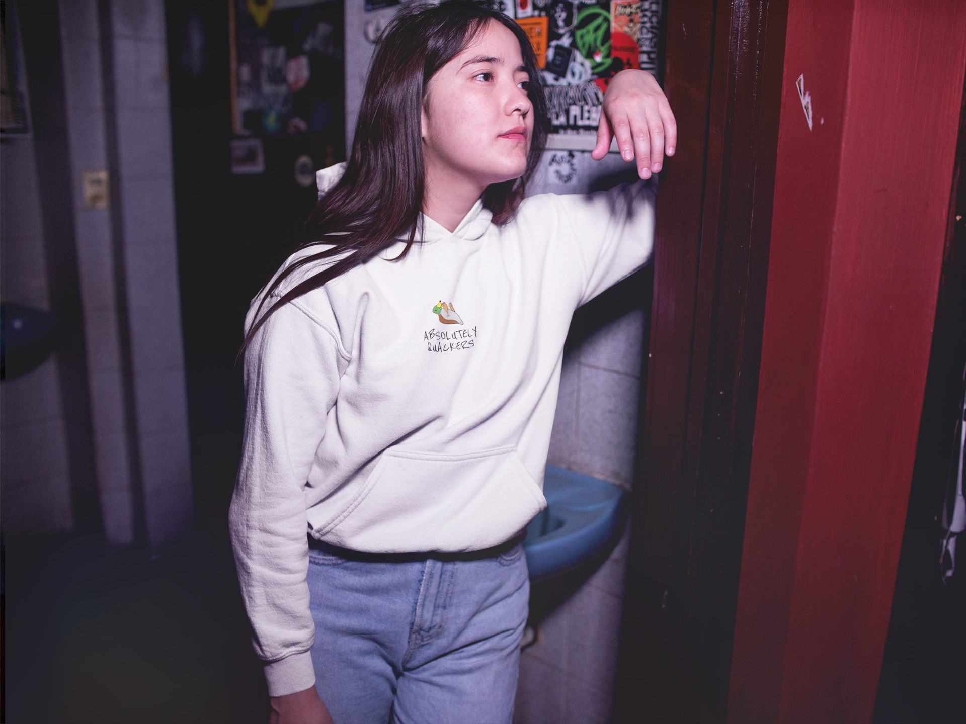 young-girl-wearing-a-pullover-hoodie-while-waiting-outside-a-bathroom-a13593.png