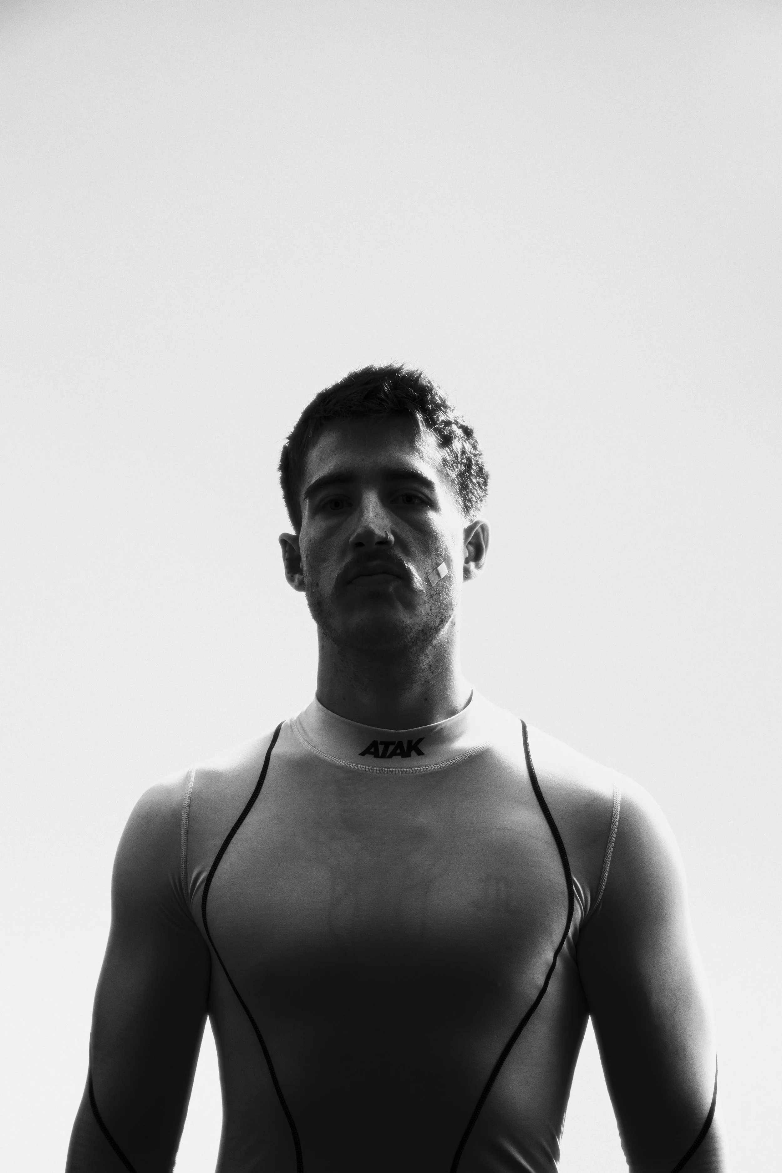 Fashion portræt af ung mand i trænningstrøje i kontrastfyldt lys - Sort/hvid Studiesetting