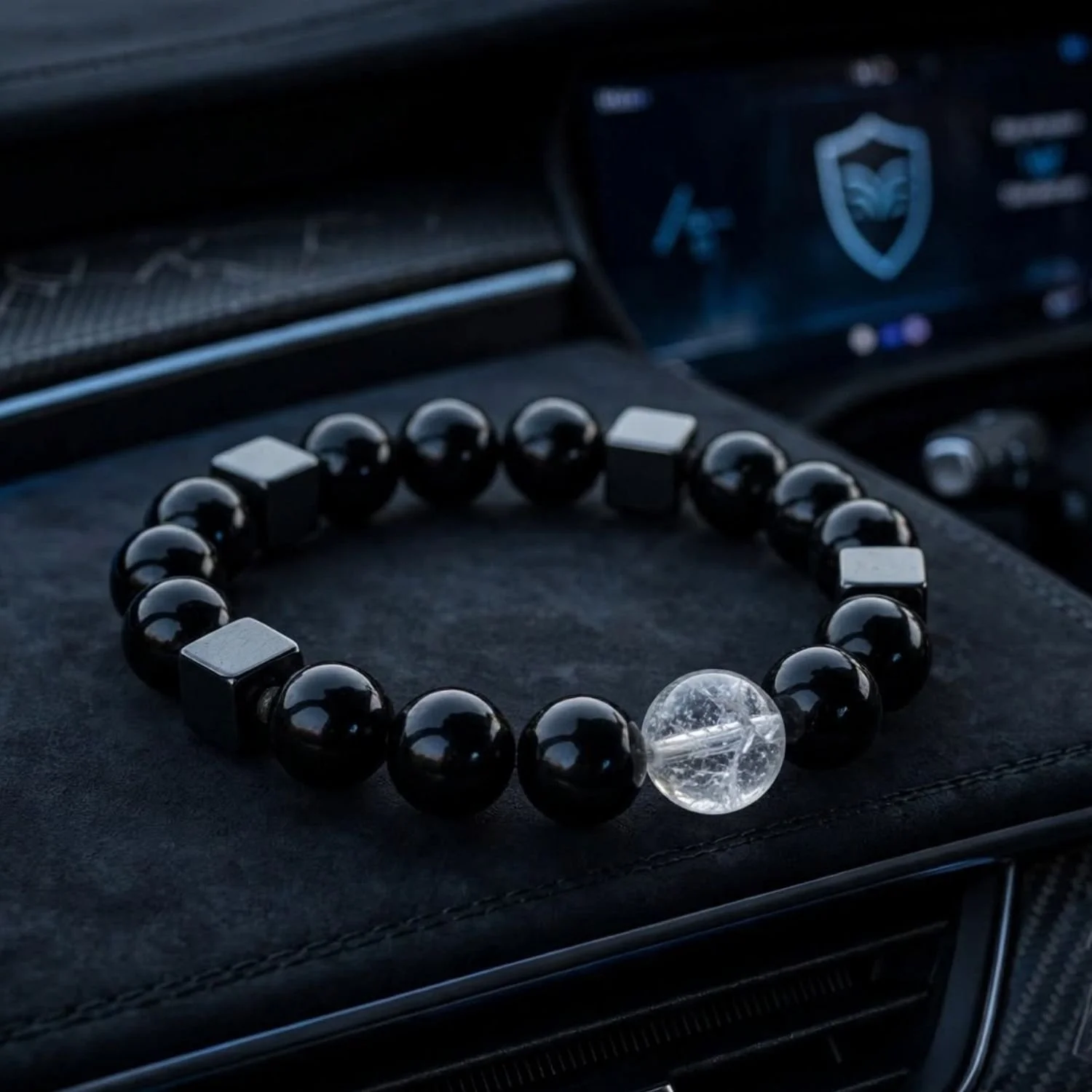Shield Drive Armband aus Schungit, Hämatit, Turmalin und Bergkristall auf der Ablage einer E-Auto-Mittelkonsole