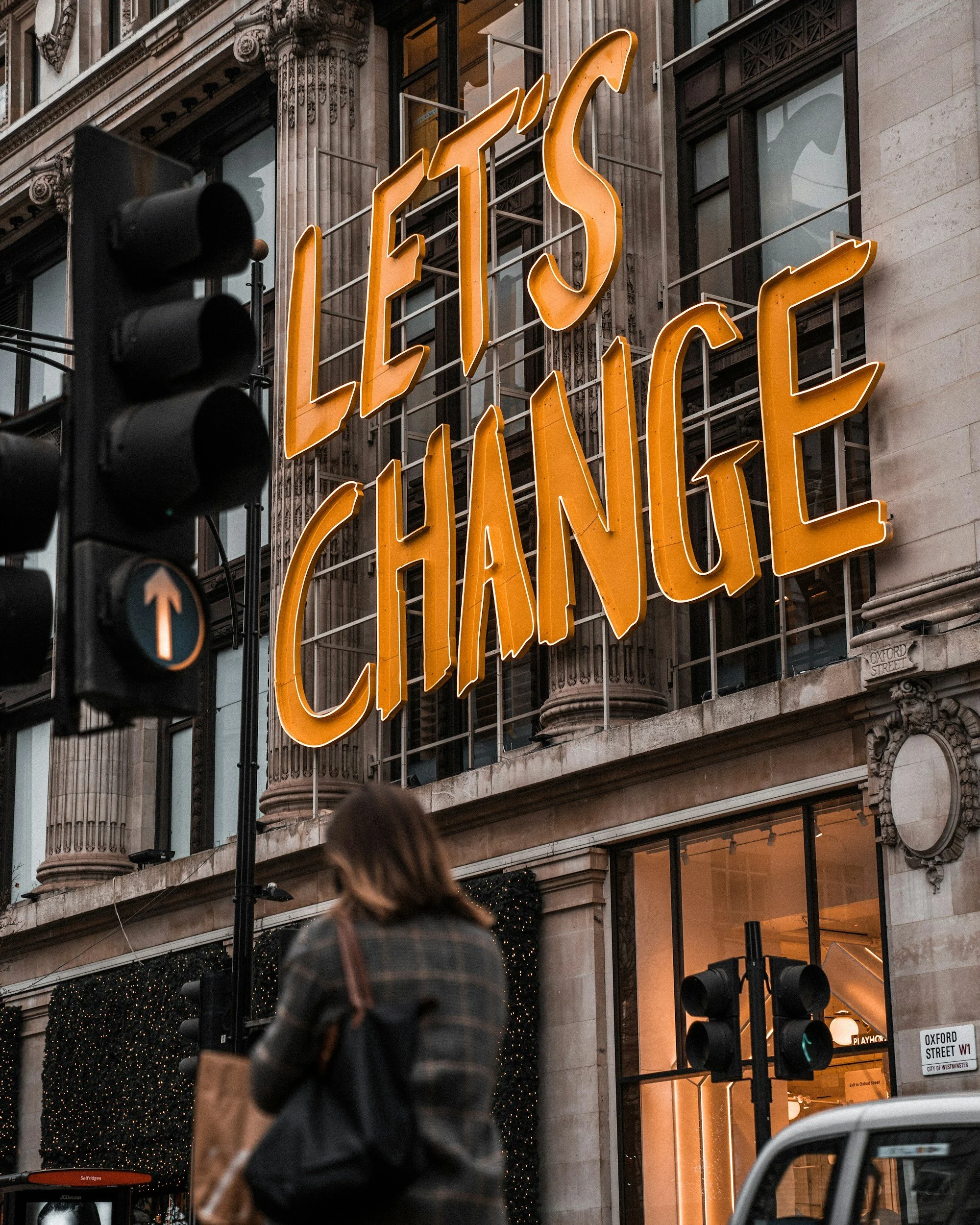 Large yellow Sign on a building saying Let's Change in