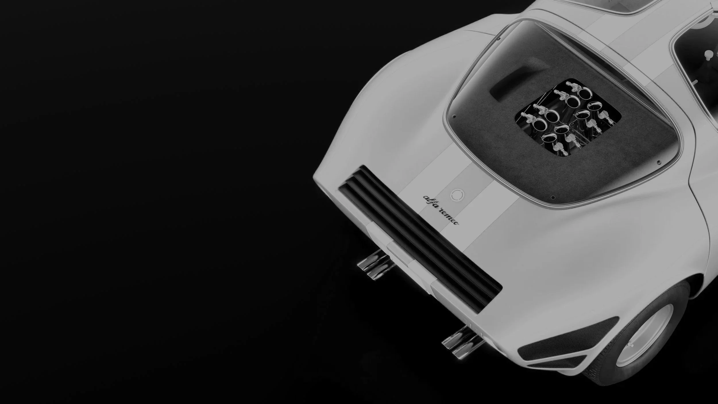 Une voiture de collection blanche vue de l'arrière, avec un moteur visible à l'arrière, sur fond noir.