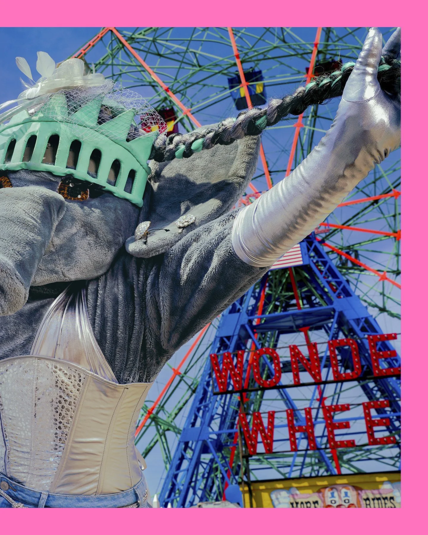 A person wearing a costume of the Statue of Liberty with a Ferris wheel in the background and a sign that reads 'WONDER WHEEL' at Coney Island.